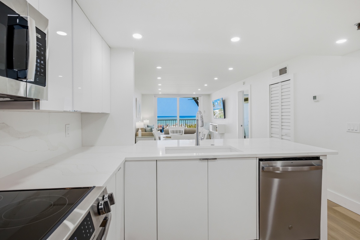 Your bright modern kitchen opens to stunning ocean views, featuring sleek appliances and pristine countertops for effortless meal preparation.