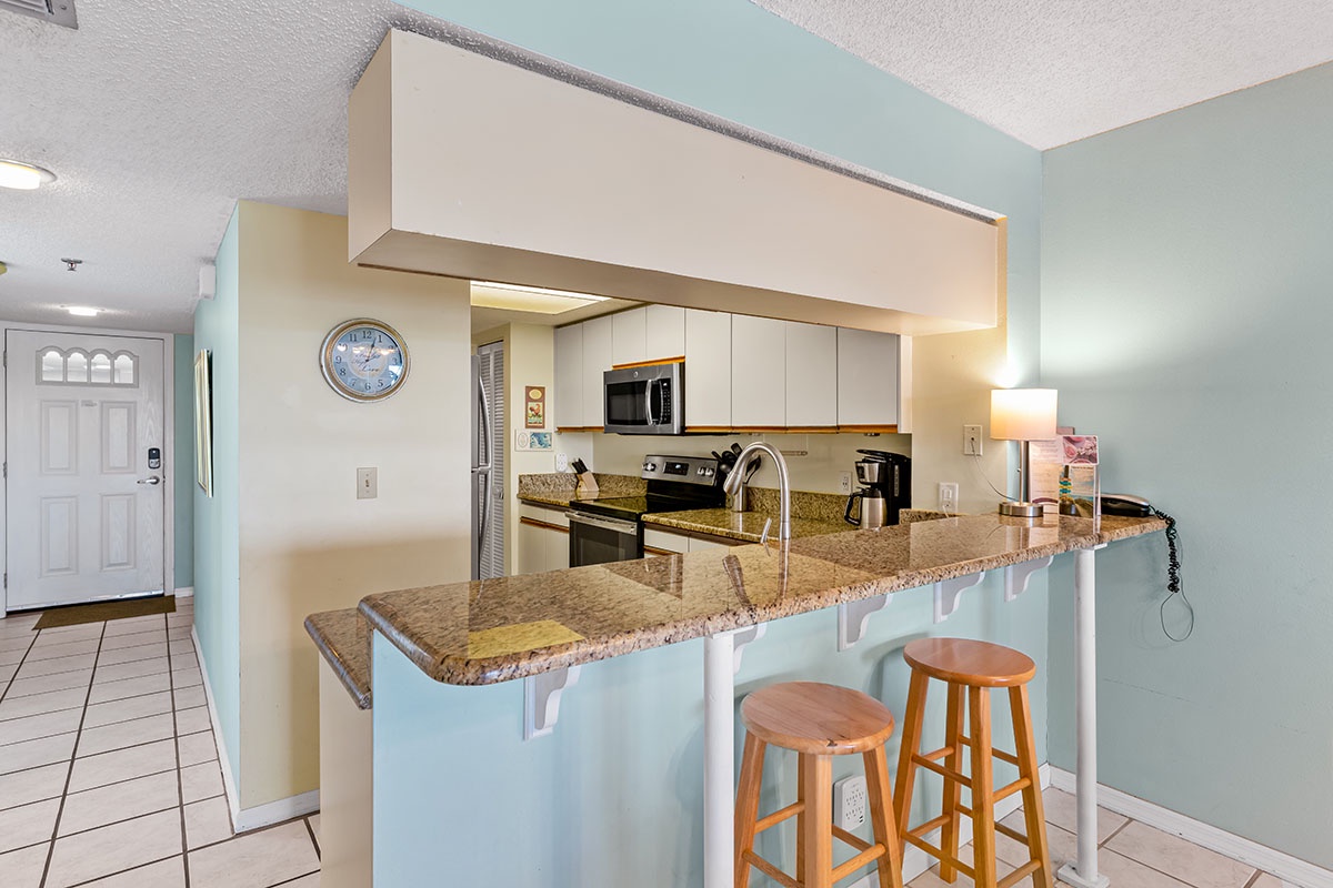 Your fully equipped kitchen features granite countertops, modern appliances, and a convenient breakfast bar—perfect for morning coffee or casual meals.