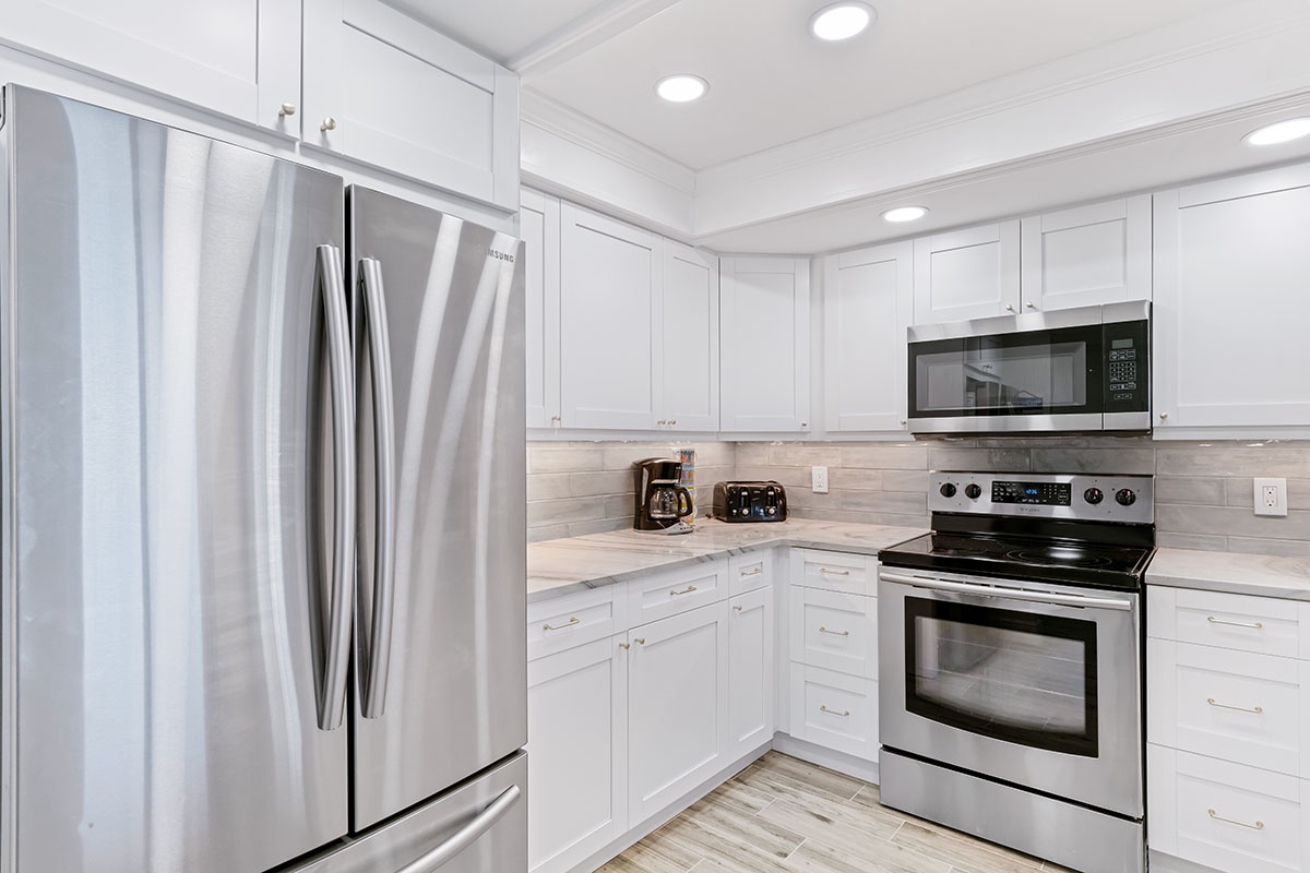Your fully equipped kitchen features modern stainless steel appliances and crisp white cabinetry, perfect for preparing meals during your stay.