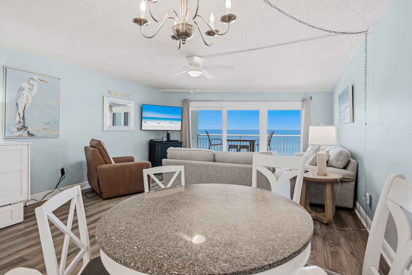 Relax in your bright, coastal-inspired living space with breathtaking ocean views through expansive balcony doors. Soft blues and natural textures create a serene beach retreat where you can unwind in comfort.