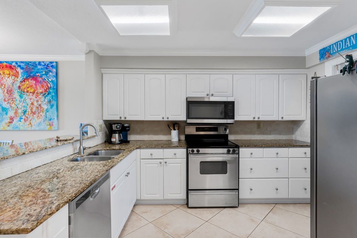 Your fully equipped kitchen awaits with granite counters, stainless appliances, and cheerful skylights—perfect for preparing meals during your coastal getaway.