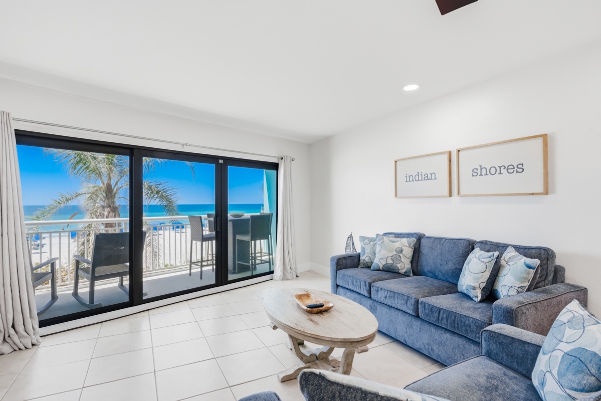 Relax in your coastal-themed living room with ocean views through floor-to-ceiling windows. Sink into plush blue sofas while enjoying stunning sea vistas.