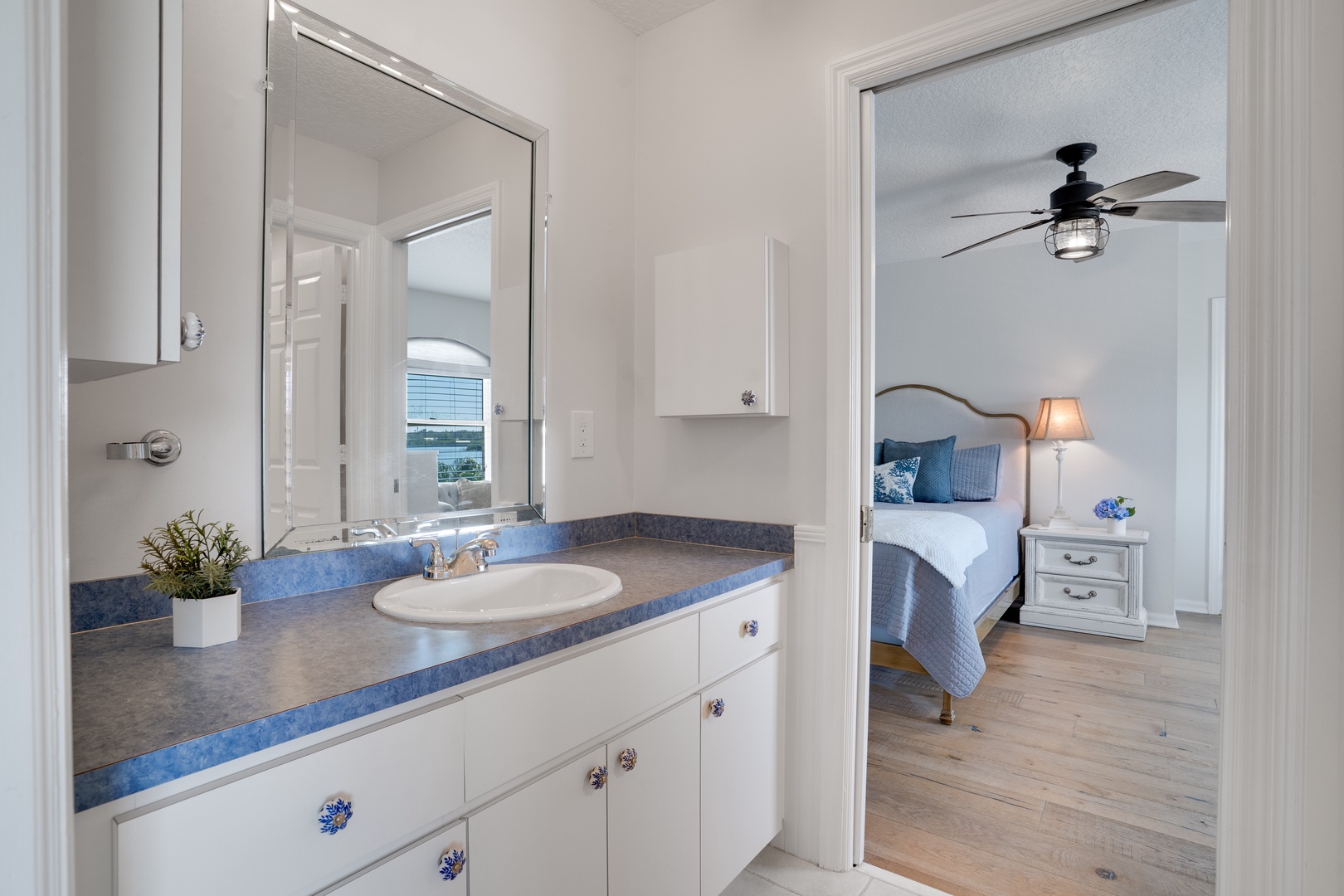 Your private ensuite bathroom features elegant blue countertops and flows seamlessly into the cozy bedroom retreat.