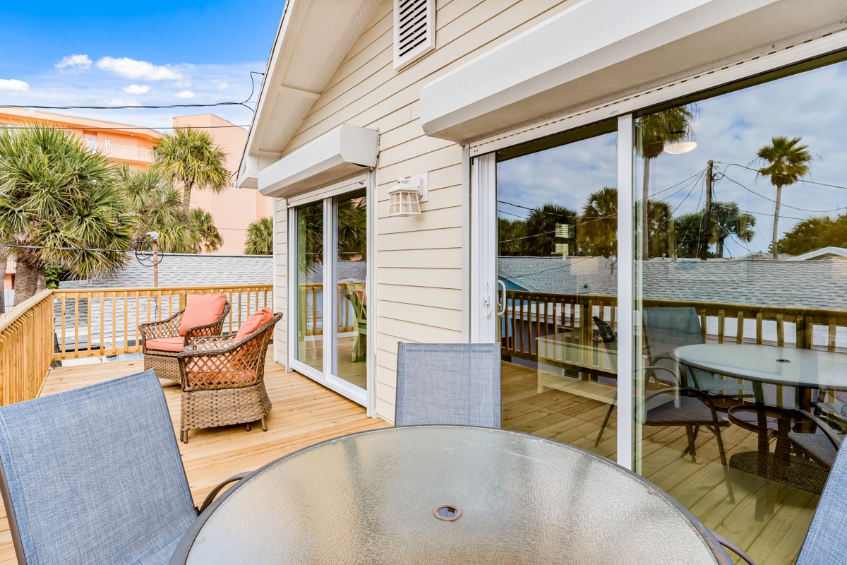 Your private deck awaits with comfortable seating, tropical palm views, and plenty of space to dine al fresco or simply unwind in the warm coastal breeze.
