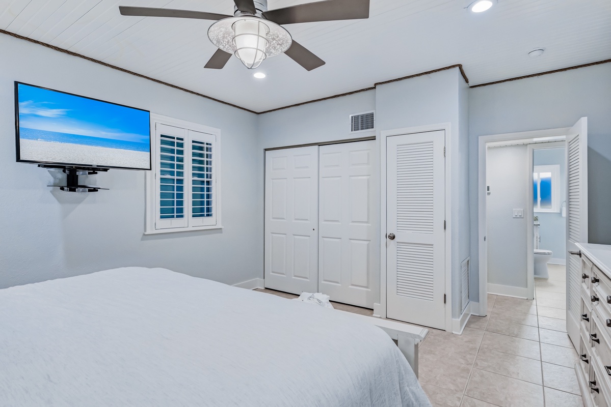 Your spacious bedroom features a ceiling fan, large TV, and ample closet storage for a comfortable stay.