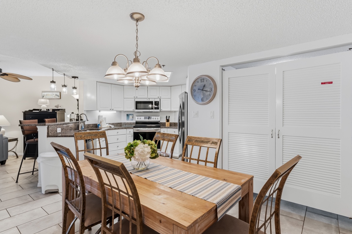 Inviting dining table with fresh flowers and striped runner, perfectly situated steps from the fully-equipped kitchen for easy meal preparation.