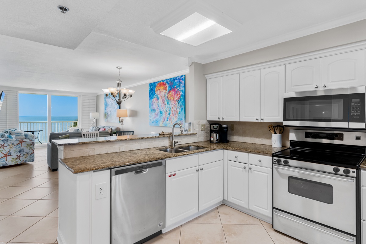 Your oceanfront kitchen invites culinary adventures with granite counters, full appliances, and stunning sea views through expansive windows.