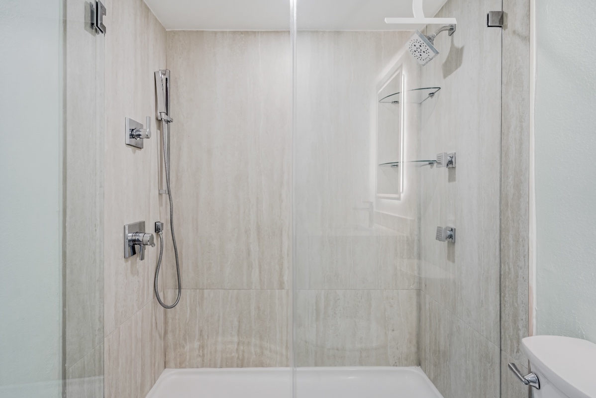 Step into your sleek marble shower with rainfall and handheld options for the perfect rinse after exploring.