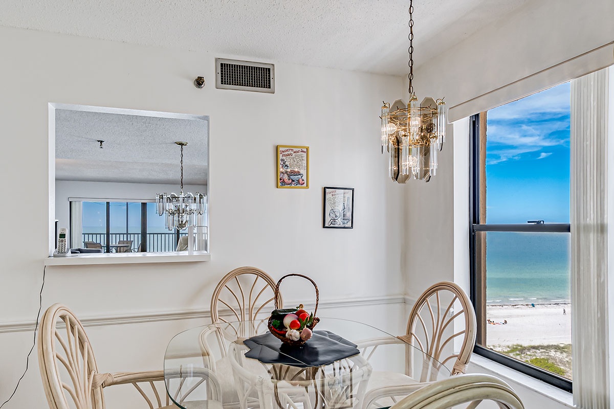 Your elegant dining area features stunning ocean views through floor-to-ceiling windows, creating the perfect backdrop for memorable meals by the sea.