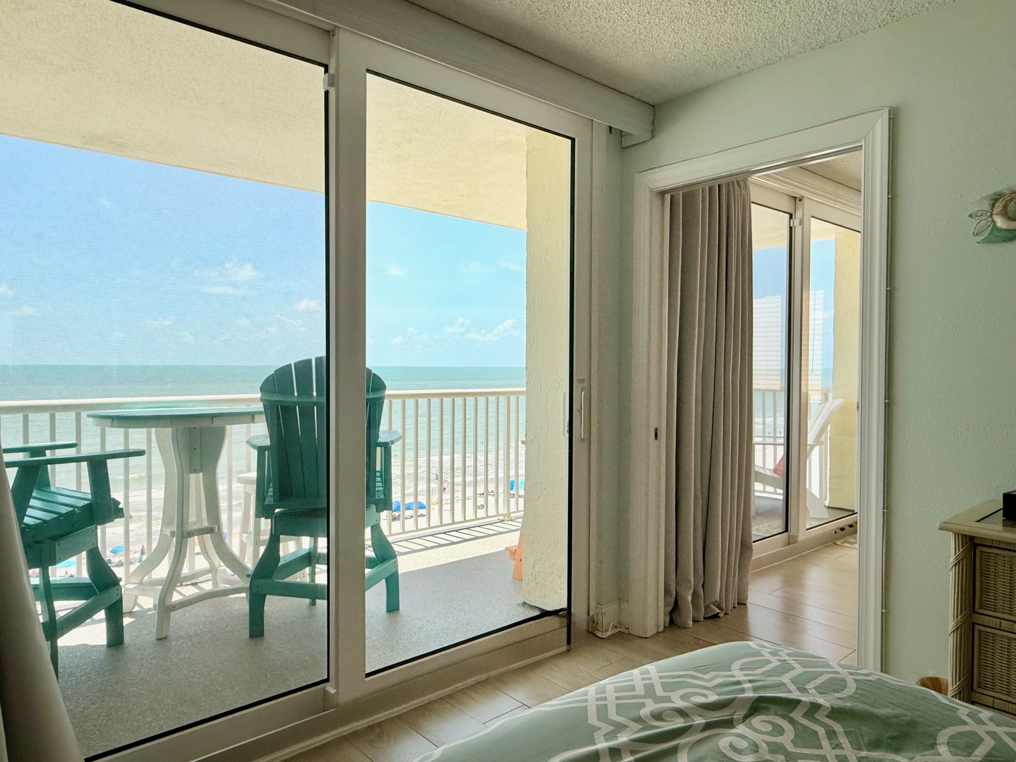 Step out onto your private balcony, where turquoise Adirondack chairs await as your ocean-view unfolds in endless shades of blue—perfect for morning coffee or sunset moments just steps from your bed.