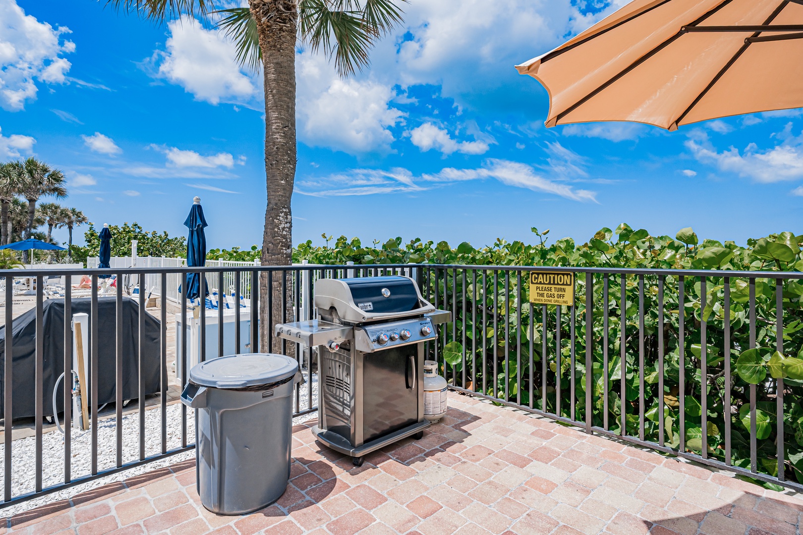 Grill your favorite meals on your private balcony overlooking lush tropical greenery and sparkling pool views under sunny skies.