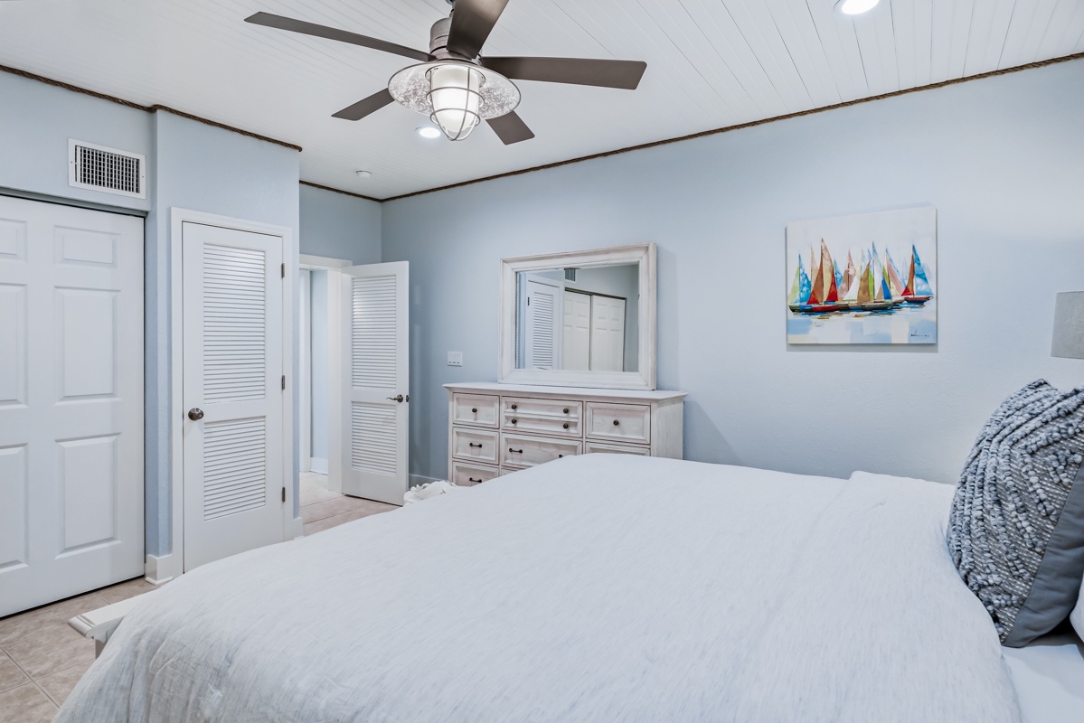 Rest peacefully in your coastal-inspired bedroom with soft blue walls, crisp white linens, and nautical artwork creating a serene seaside retreat.