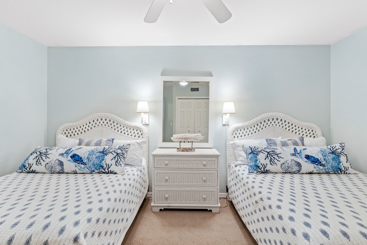 2 Queen beds with ocean-themed linens create your perfect coastal retreat, while the ceiling fan ensures refreshing nights.