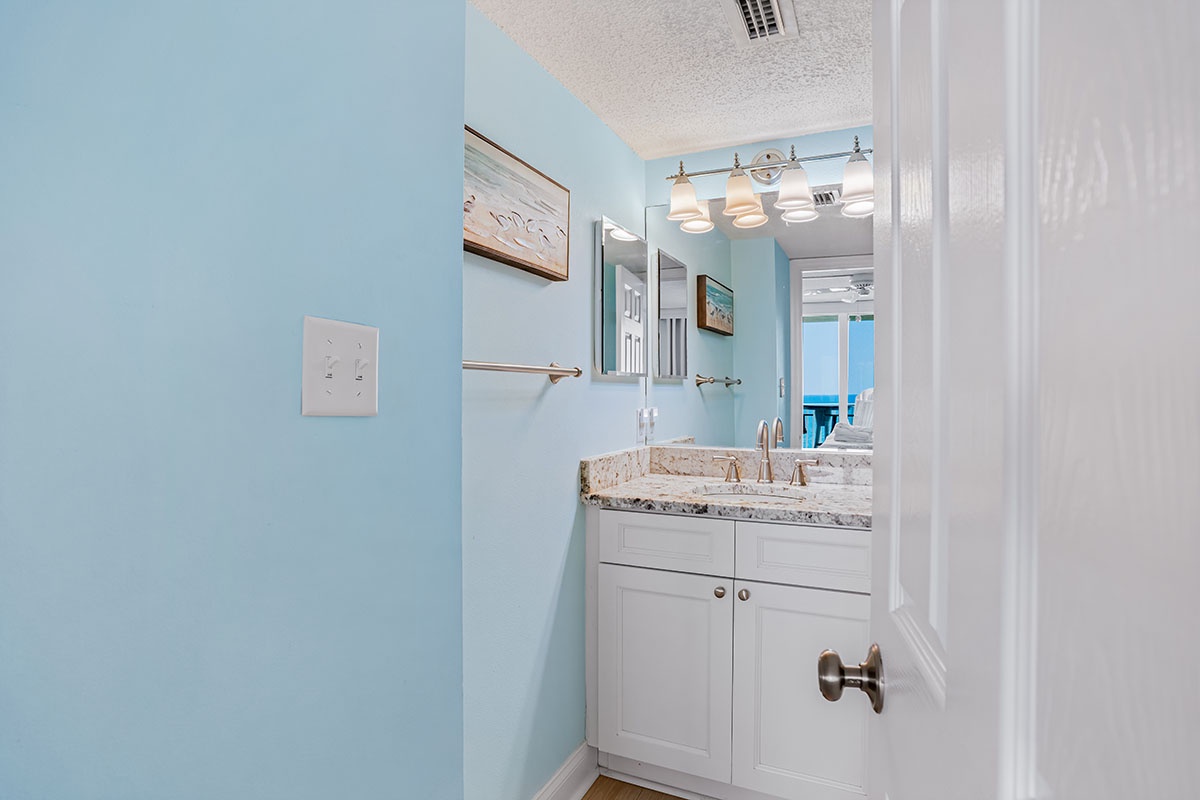 Fresh up in your private bathroom with elegant granite countertops, modern lighting, and calming coastal blue walls that instantly put you at ease.