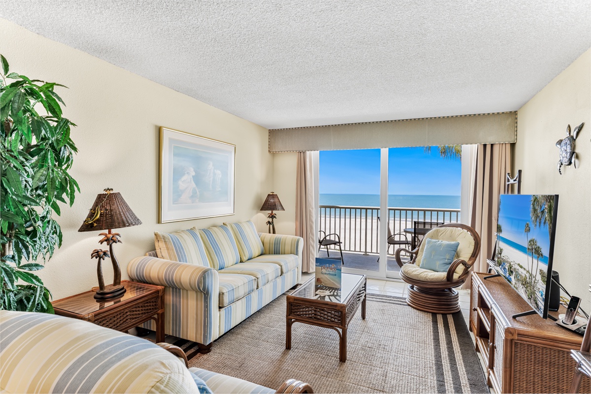 Unwind in your bright coastal retreat, where gentle breezes drift through the open balcony doors and stunning ocean views frame your relaxation. Comfortable seating invites you to sink in and soak up the sunshine.
