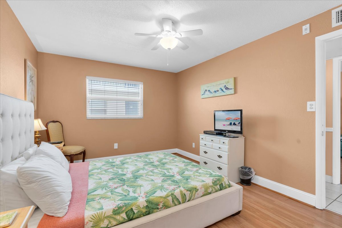 Your bright ensuite bedroom features a comfy bed with tropical linens, a ceiling fan for warm nights, and a TV for unwinding after a day of adventure.