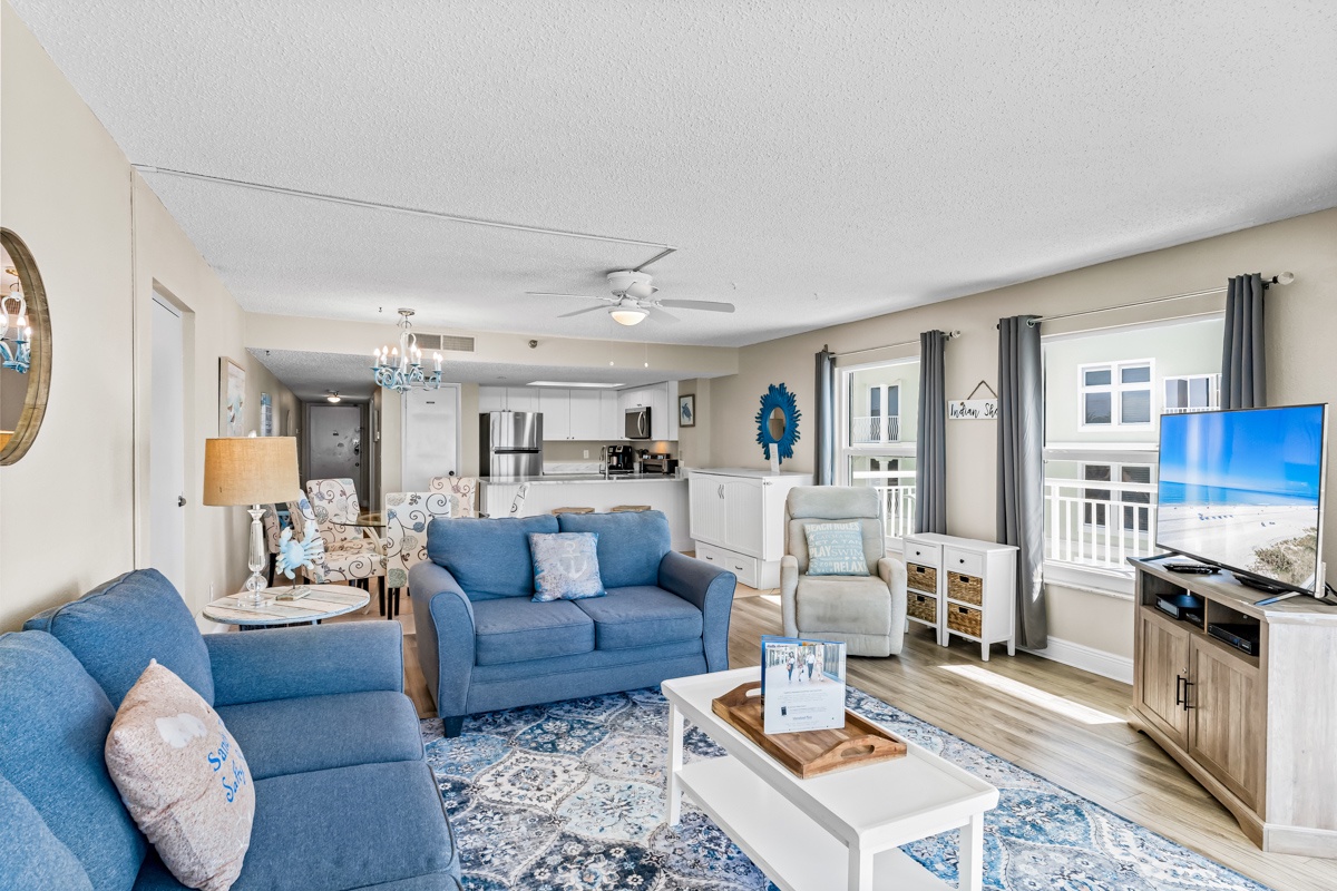 Relax in this bright, coastal-themed living space where soft blue furnishings and ocean-inspired decor create your perfect beach getaway retreat.