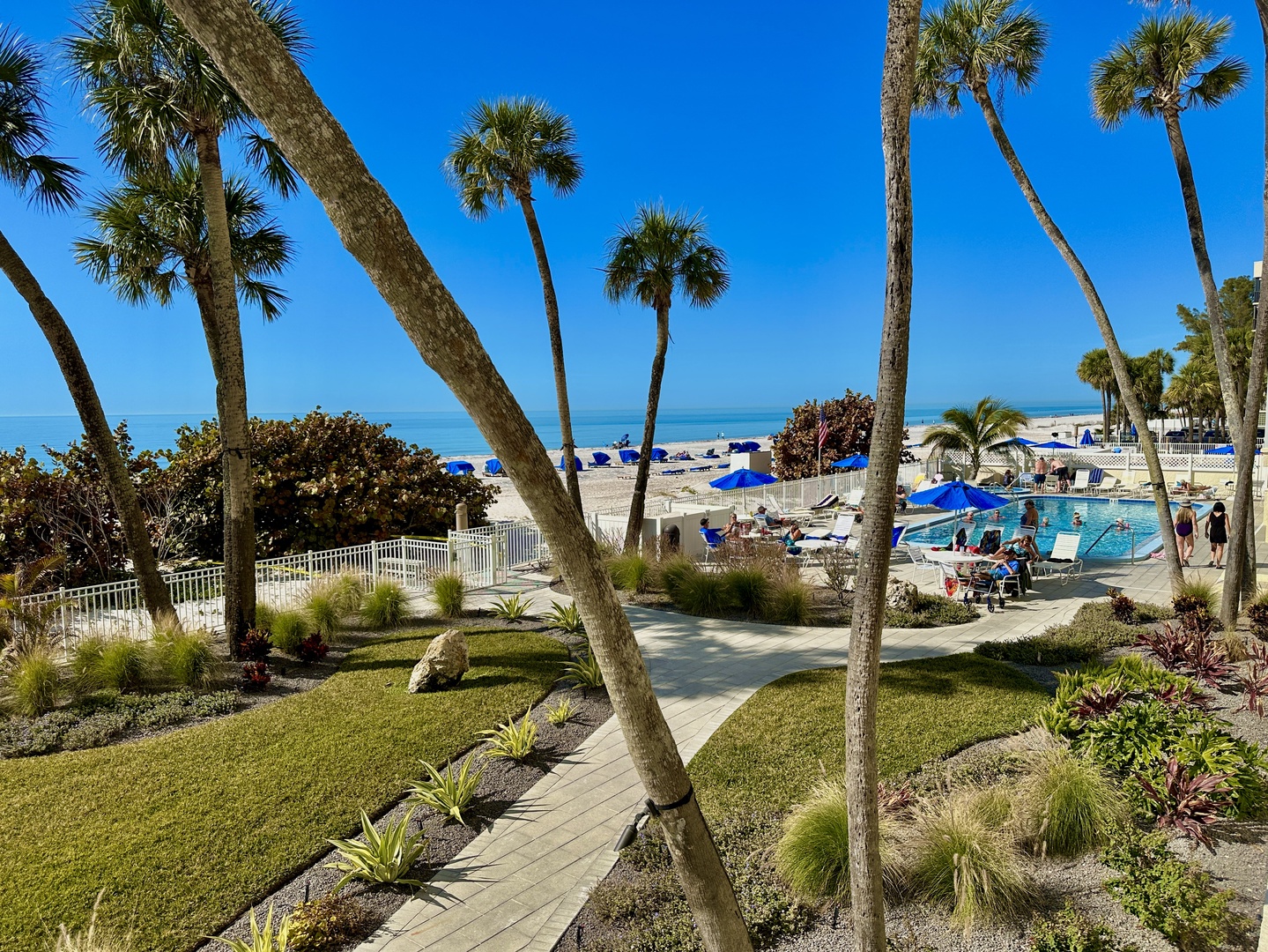 A tropical paradise with swaying palms, pristine beach access, and sparkling pool just steps from the sand.