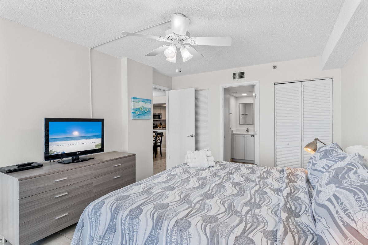 Unwind in your serene bedroom featuring crisp linens, modern furnishings, and your own entertainment center for cozy evenings.