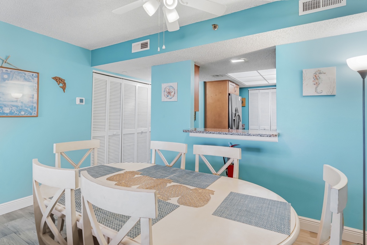Gather around the bright dining table with coastal charm, where breezy turquoise walls and playful marine artwork set the tone for your meals together.