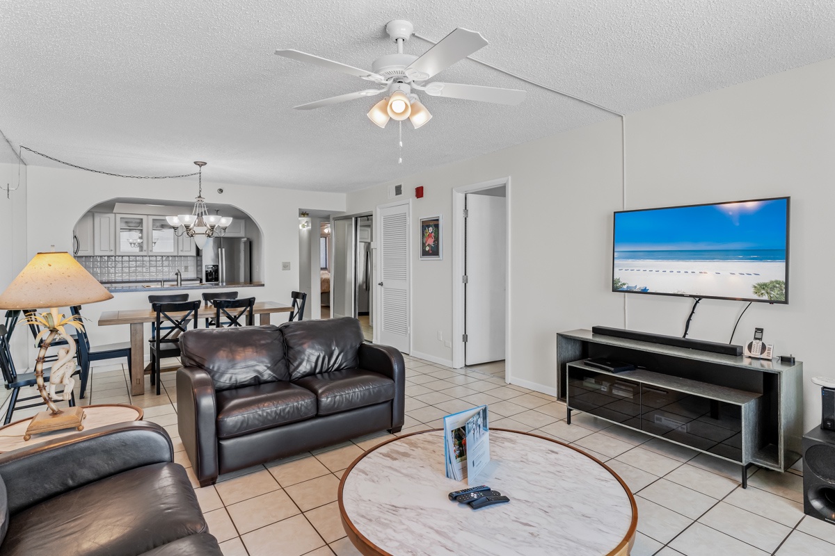 Unwind in your spacious living area with plush leather seating, entertainment center, and open kitchen - perfect for your beach getaway relaxation.
