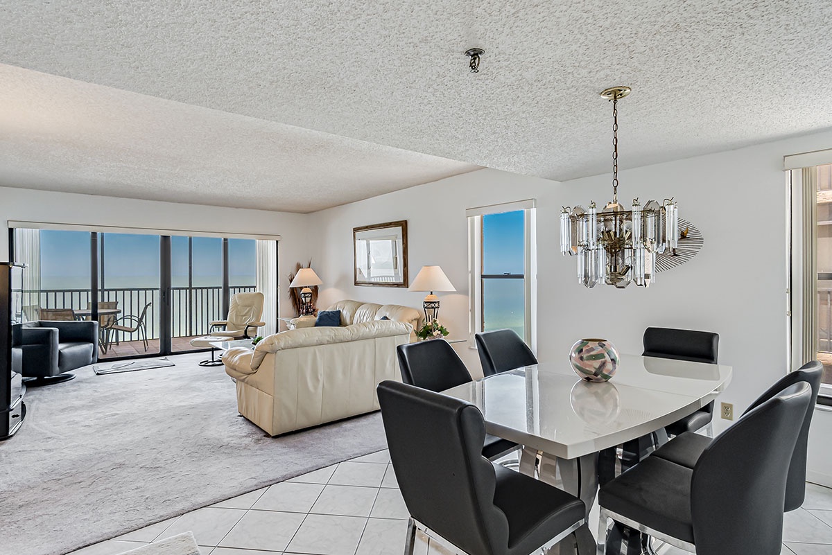 Your elegant dining area flows seamlessly into a comfortable living space with stunning ocean views through floor-to-ceiling windows that fill your home with natural light.