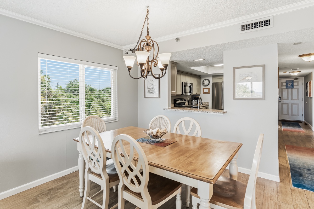 Gather around the table for meals and memories in this bright dining space with a view of the kitchen, perfect for your group to reconnect and share stories over delicious home-cooked meals.