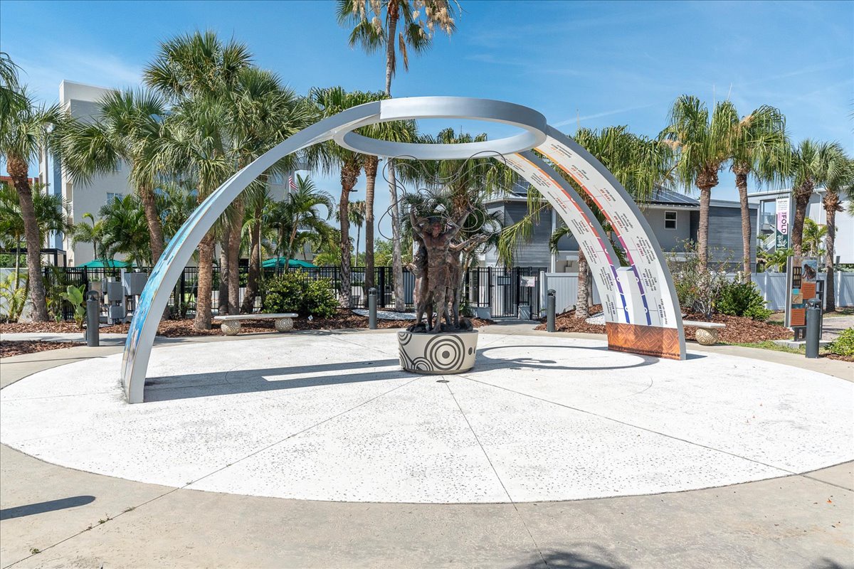 This artistic arch across the street surrounded by tropical palms in a sunny coastal neighborhood.