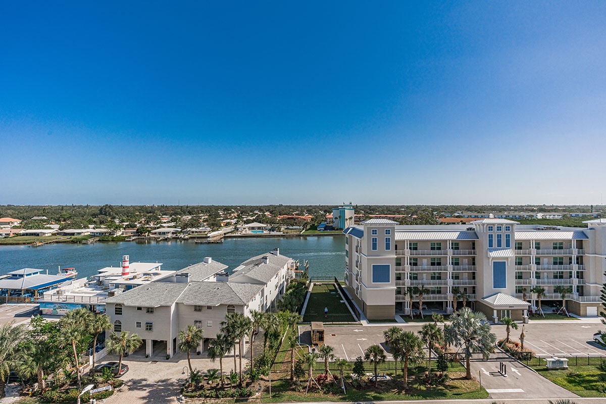 Waterfront resort complex featuring modern accommodations along pristine marina waters with tropical landscaping and scenic coastal views.