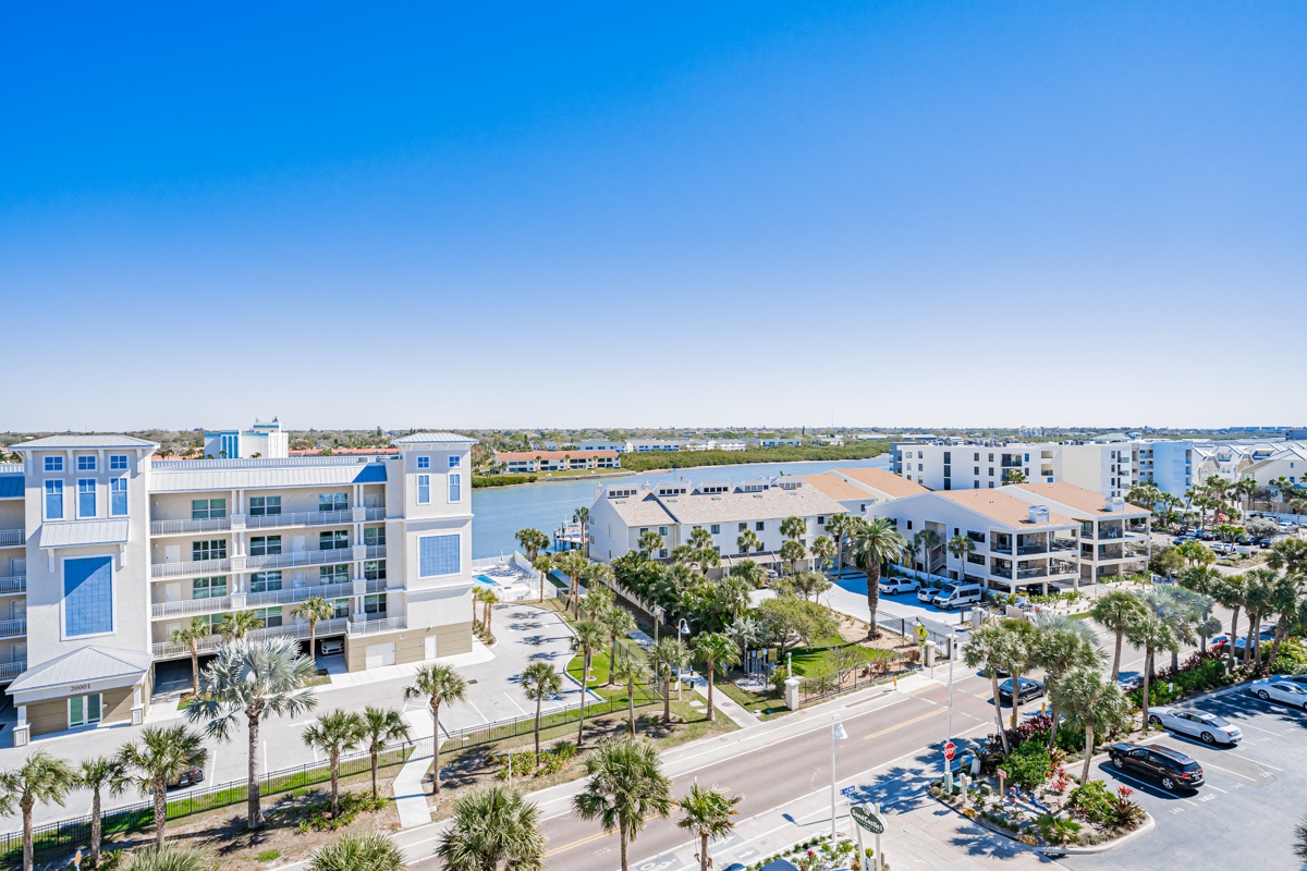 Aerial view showcases the modern beachfront resort complex surrounded by palm trees and tropical landscaping in this coastal destination.
