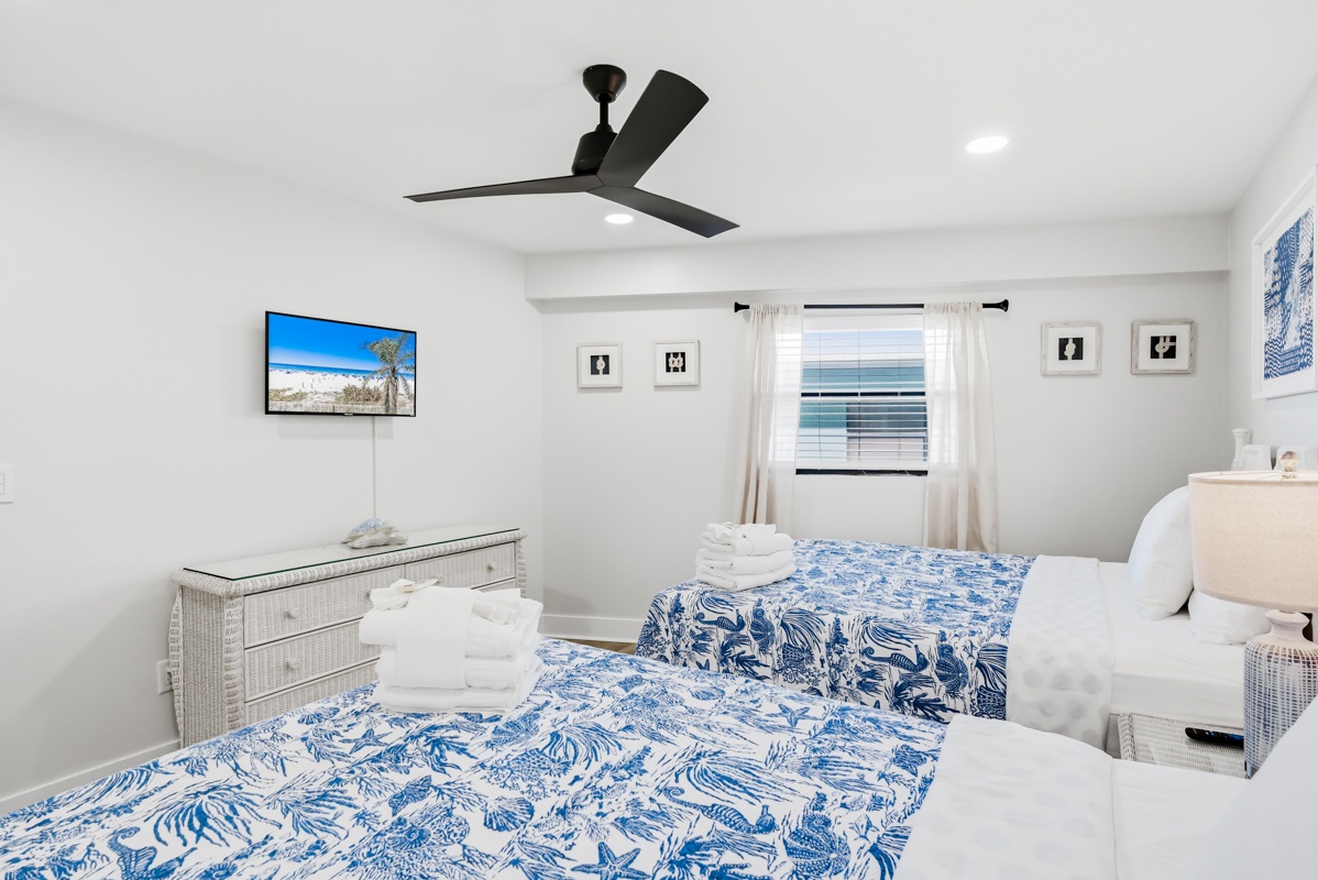 Drift into peaceful dreams in your serene 2 Queen bedroom, featuring crisp linens and coastal decor that captures the ocean's tranquil spirit.