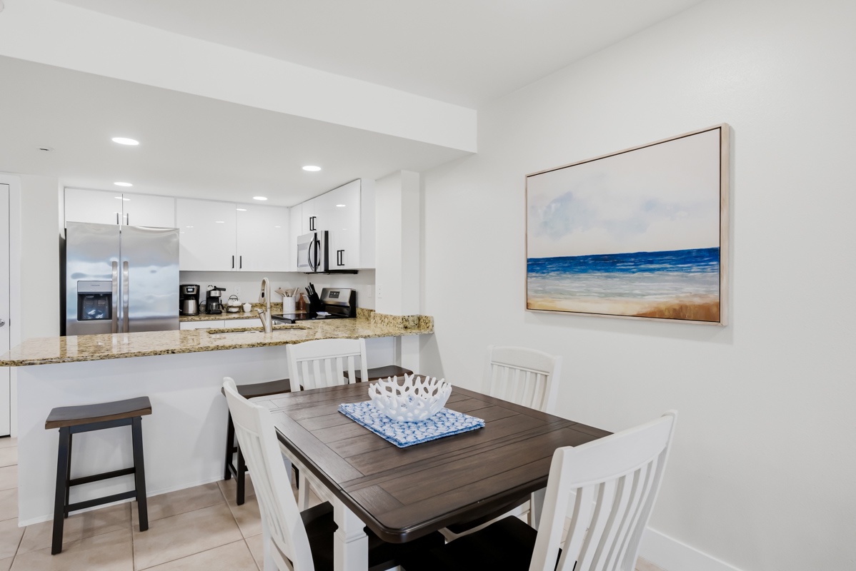 Gather around your bright dining space, where modern convenience meets coastal charm. The open kitchen invites easy entertaining.