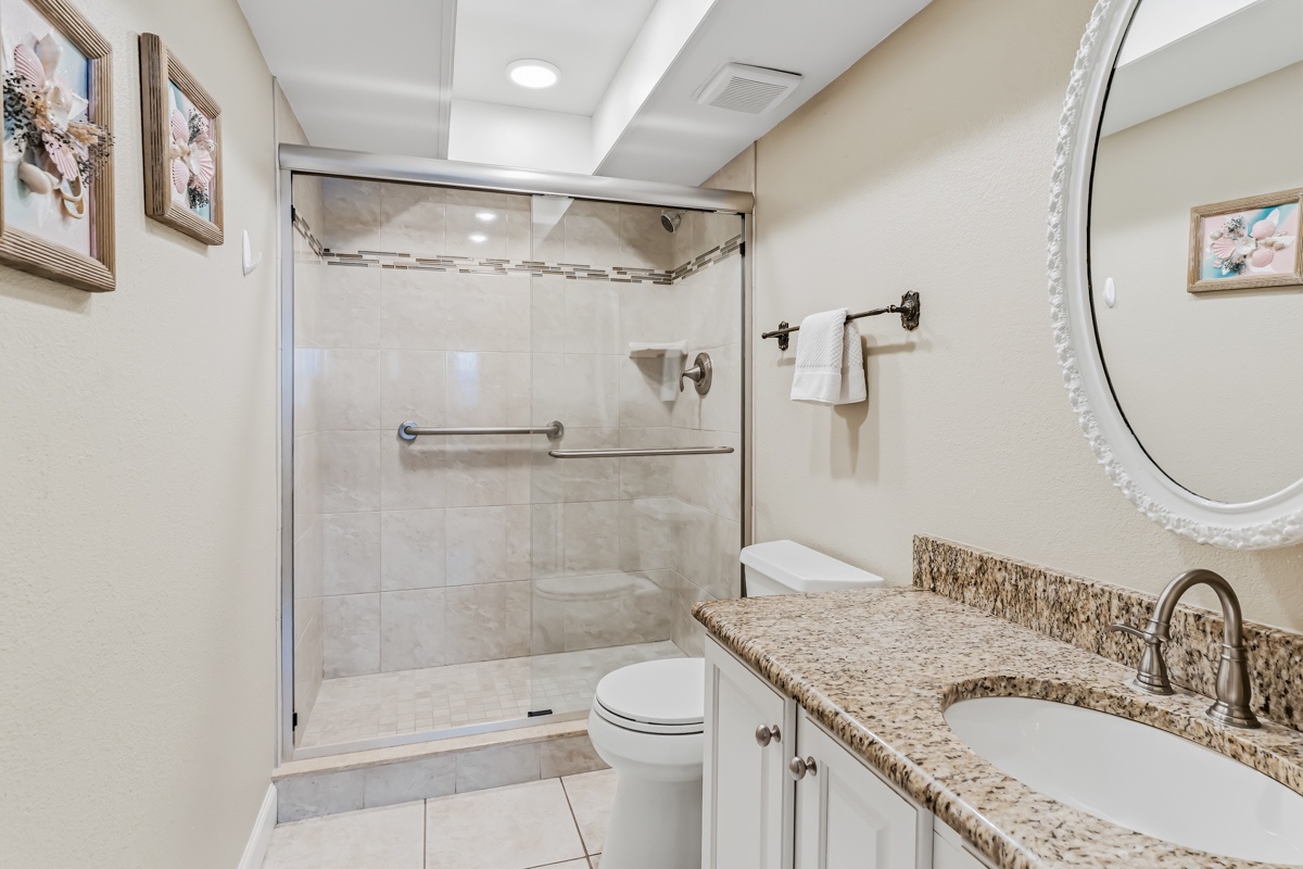 Freshen up in this beautifully tiled bathroom featuring a spacious walk-in shower, granite countertops, and sparkling clean finishes. Enjoy the convenience of ample counter space and soft towels after your daily adventures.