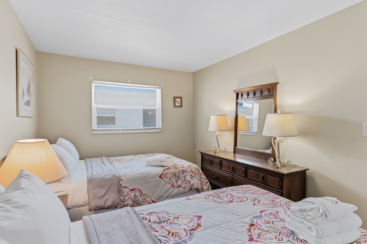 Settle into your peaceful twin bedroom with warm lighting and classic wood furnishings. The neutral tones and soft linens create a calming retreat after your adventures.