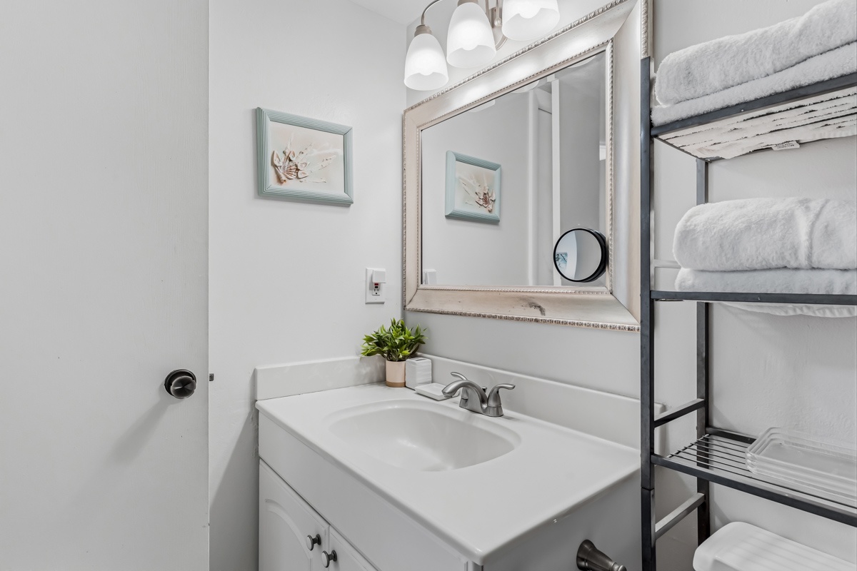 Step into your fresh, bright bathroom with coastal accents and soft towels waiting for your arrival.