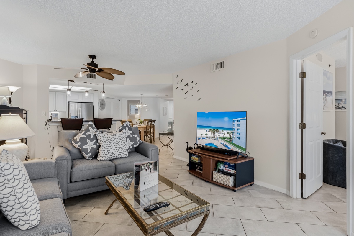 Step into a bright, airy space with stylish coastal-inspired décor and open-concept living that flows effortlessly from lounge to kitchen and dining. Relax on plush seating under the gentle breeze of a ceiling fan.