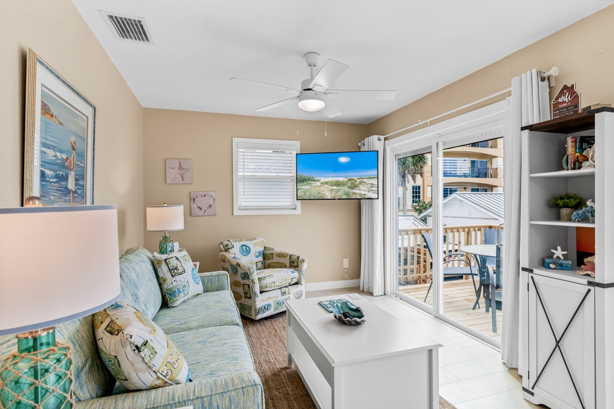 Unwind in your bright living room with ocean-themed decor and sliding doors opening to your private balcony with outdoor seating.