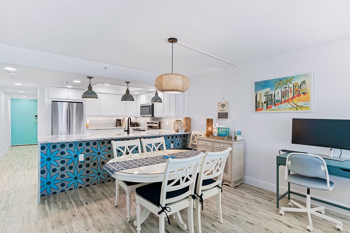 Embrace coastal vibes in your bright open kitchen with vibrant blue tile and dining space perfect for morning coffee or evening meals.