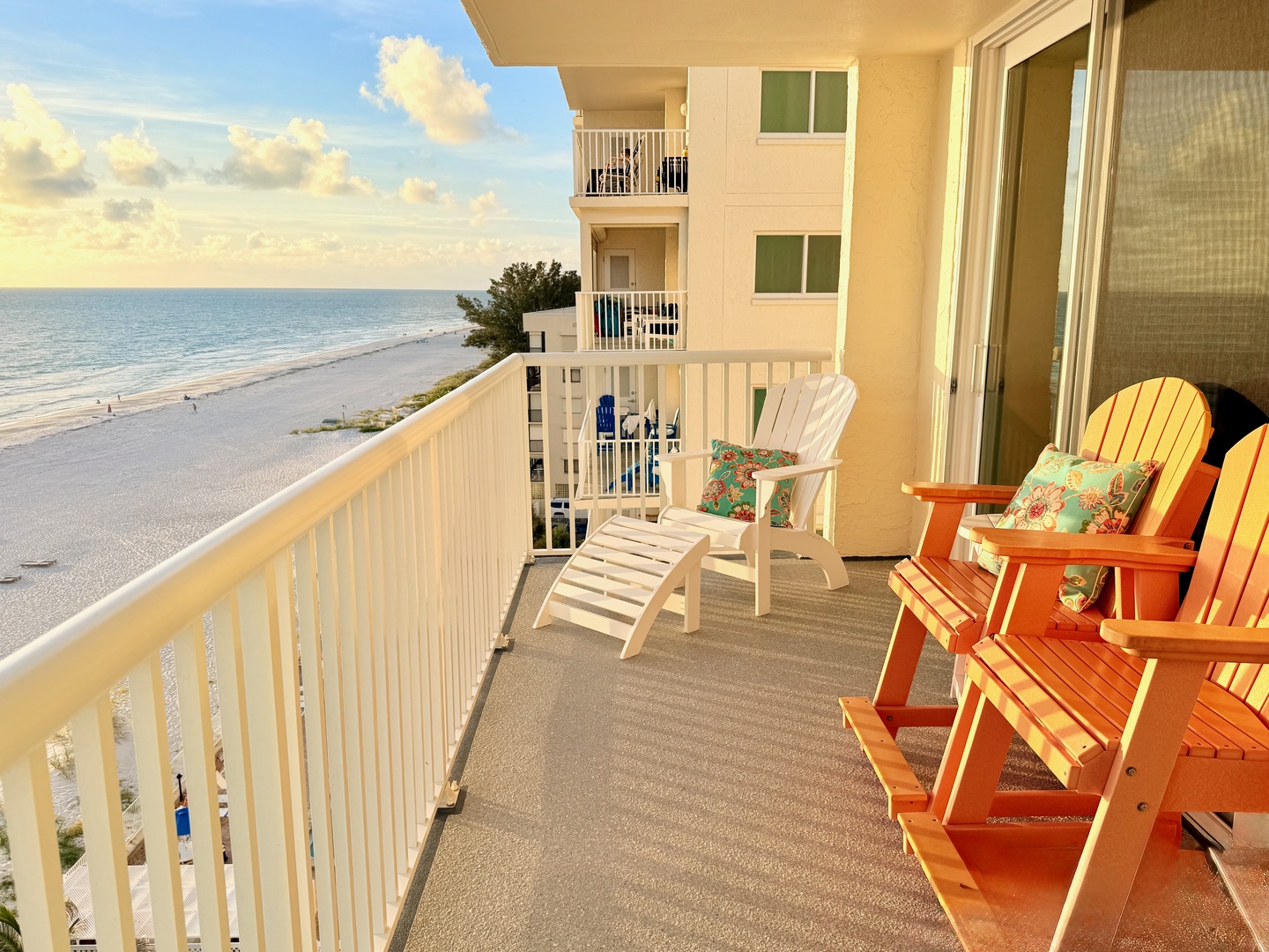 Step onto your private balcony and let the ocean breeze wash over you. Sink into the colorful Adirondack chairs, feel the warm evening glow, and watch gentle waves meet the shore just steps away—pure coastal bliss.