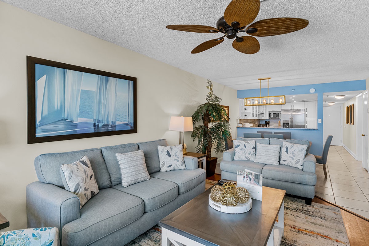 Relax in your spacious living room with coastal-inspired décor, comfortable seating, and an open kitchen perfect for vacation meals.