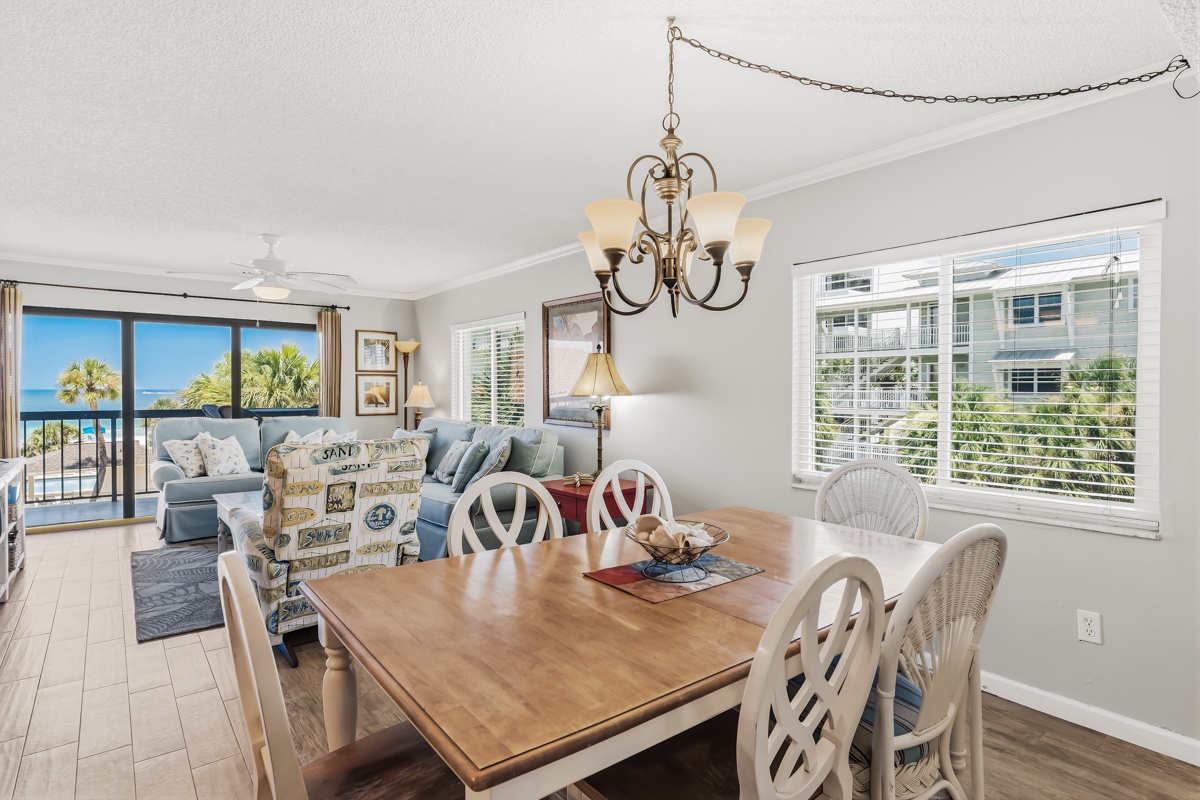 Gather around this welcoming dining space where your vacation meals become cherished memories. Through the windows, you'll glimpse palm trees and ocean views—your coastal escape awaits.