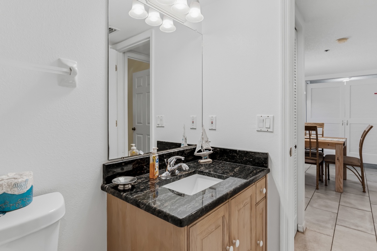 Your private bathroom features a polished granite vanity with ample counter space, bright vanity lighting, and fresh linens to welcome you after a day exploring.