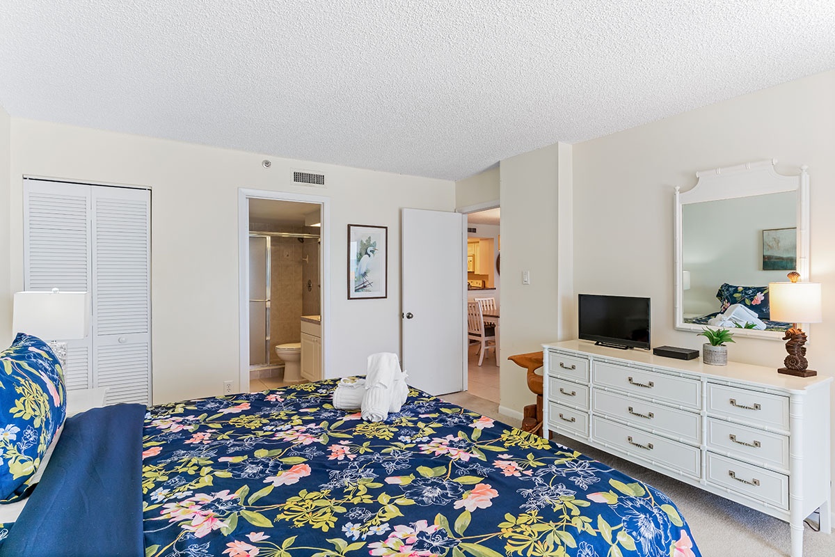 Your bright, airy bedroom features tropical-print bedding and thoughtful amenities. Unwind while watching TV or freshen up in your private ensuite.