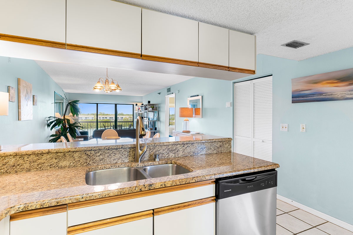 Your open kitchen features granite counters and stainless appliances, seamlessly flowing into the bright living space with stunning views beyond.