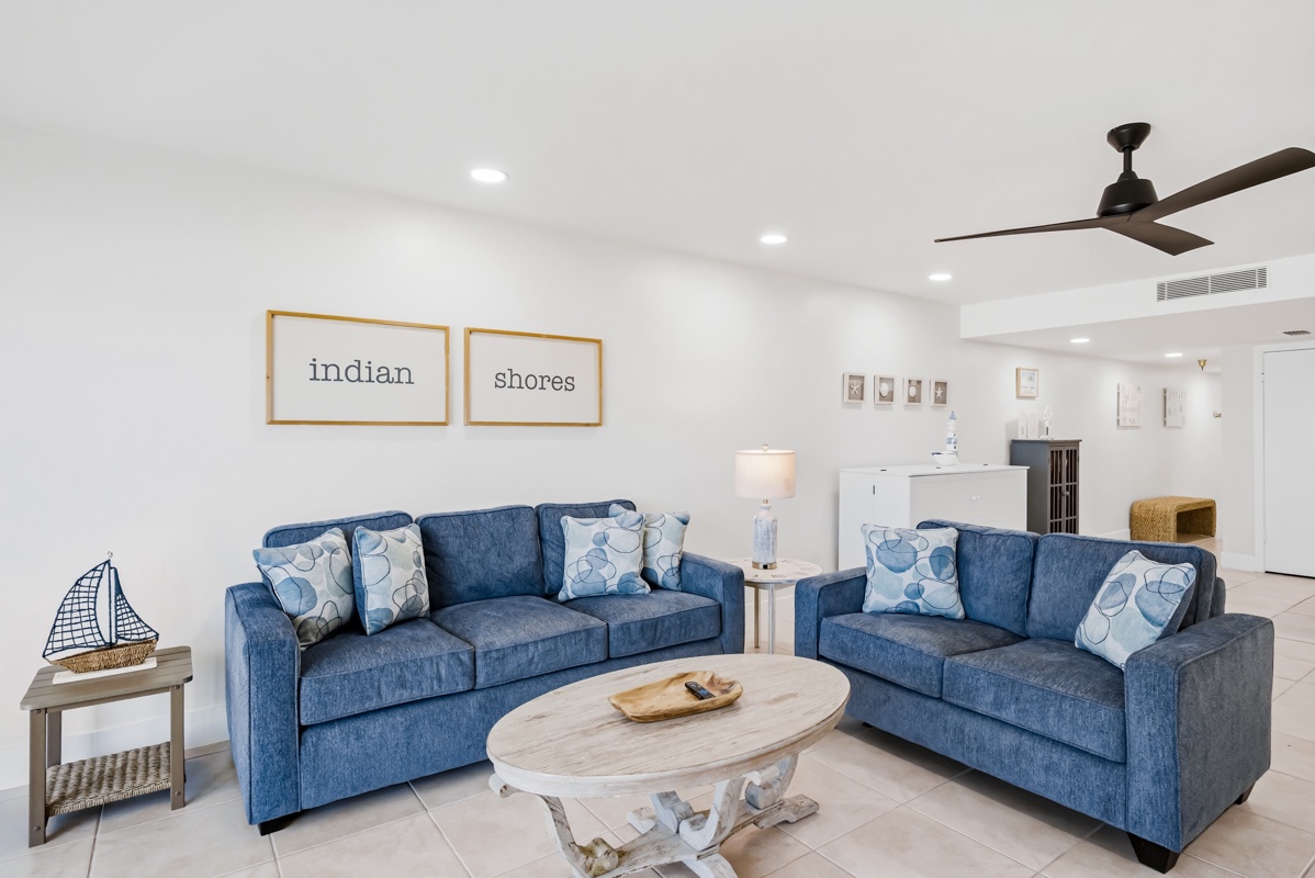 Unwind in your spacious living room with plush blue sofas and nautical touches that create the perfect coastal retreat atmosphere.