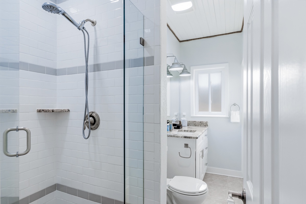 Your private bathroom features a spacious glass-enclosed shower with modern fixtures and elegant tile work for refreshing mornings.