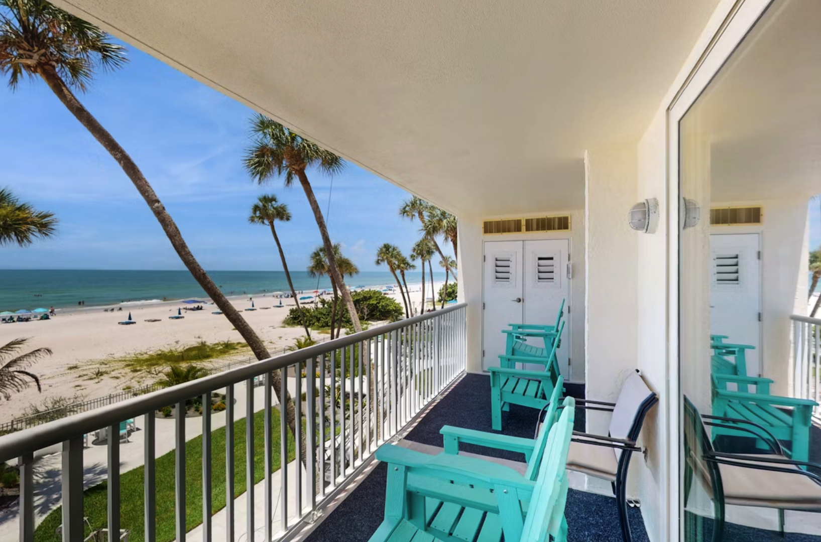The property features a beachfront location with ocean views, framed by swaying palm trees along the sandy shoreline.