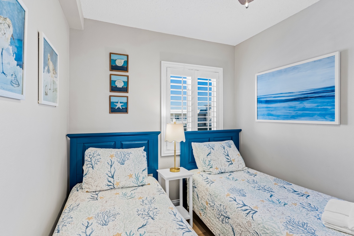 Your coastal-themed twin bedroom features ocean-inspired artwork and bright blues, creating a serene seaside retreat.