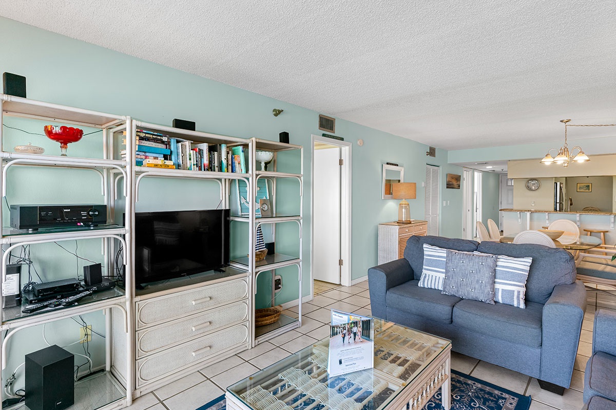 Relax in your spacious living area with comfortable seating, entertainment center, and open layout connecting to the dining space.