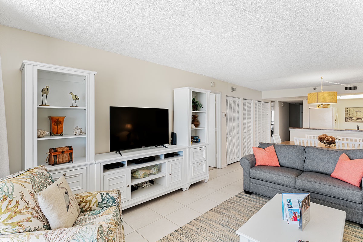 Relax in your bright living space with comfy seating, entertainment center, and coastal touches throughout this open-concept home.
